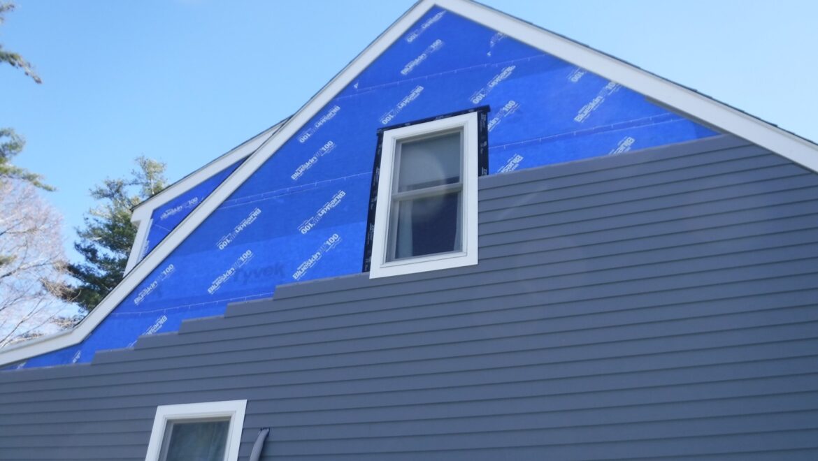 Exterior home renovation in progress in Massachusetts with new siding and weather barrier